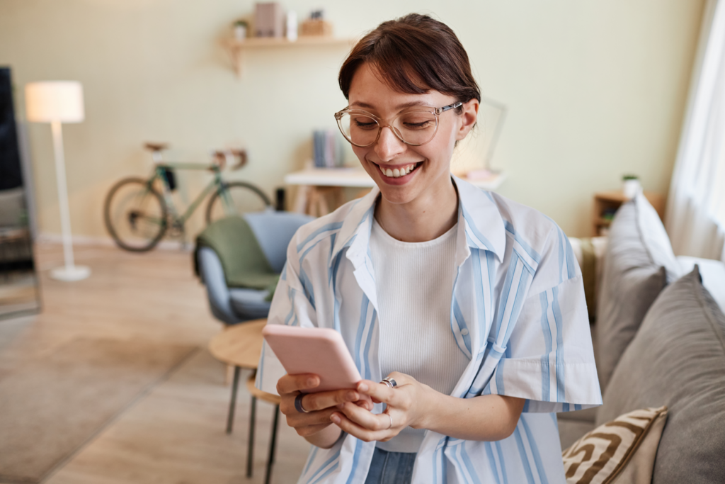 Woman using smartphone in home to calculate gross living area with CubiCasa.